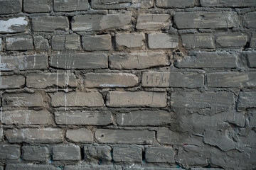 Texture of an old paint covered brick wall. Background image of an abandoned brick wall with painted over paint
