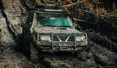 Offroad vehicle goes on the mountain. Road adventure. Adventure travel. Tracks on a muddy field. Rally racing. Off-road travel on mountain road. © Volodymyr