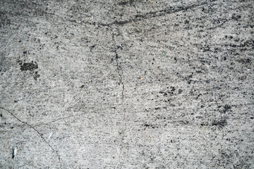 Texture of an old cracked concrete wall. Background image of a worn gray concrete surface