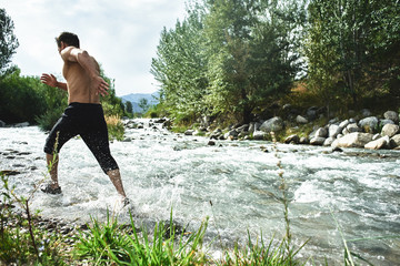 Asian athlete on a morning run on the river, Kazakh jogger in nature close-up