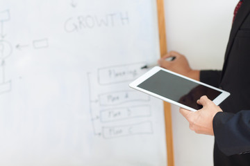 Businessmen holding a tablet are describing a business plan (Plan A, Plan B, Plan C).