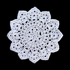 White crochet mandala isolated on black background.