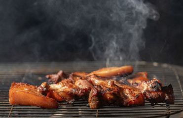 BBQ Grilled pork on the grill with smoke and steam rise from a pork steak