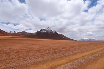 Landscape of the Bolivian highlands. Desert landscape of the Andean plateau of Bolivia with the peaks of the snow-capped volcanoes of the Andes