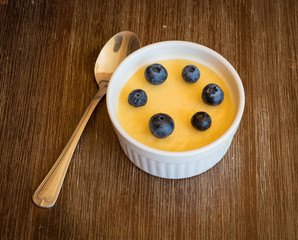 Flan with blue berry is made in ramekin.