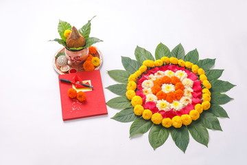  Red accounting note book , diya, and flower rangoli on white background