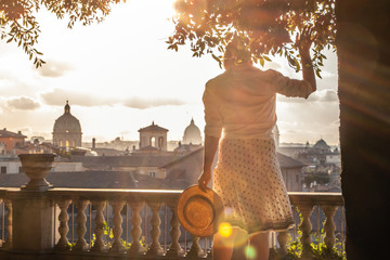 Young woman tourist in fashion white dress with hat at panoramic view of Rome cityscape from...