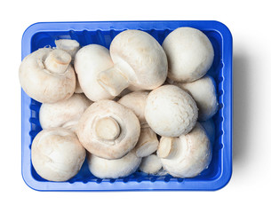 Fresh champignons in plastic packaging isolated on white background. Top view. Clipping path.