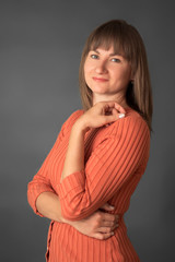 Portrait woman in orange sweater on the gray background