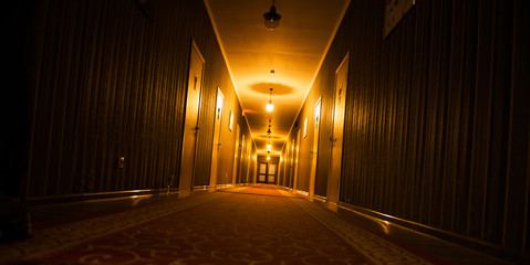 long dark vintage motel corridor with closed doors - obrazy, fototapety, plakaty