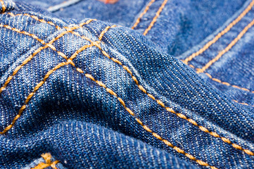 clothing items blue stonewashed faded jeans cotton fabric texture with seams, clasps, buttons and...