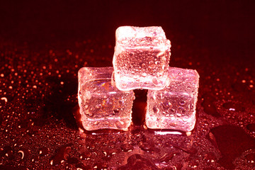 ice cubes on a reflections red light.