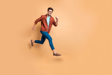 Fototapeta na wymiar Full length body size view of nice attractive cheerful cheery strong sportive successful guy leader jumping in air running fast hurry-up meeting appointment isolated over beige color pastel background
