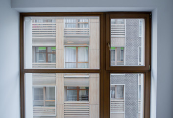 A huge window in the new apartment, through which you can see the modern new house opposite. The concept of new housing, moving, housewarming, new buildings