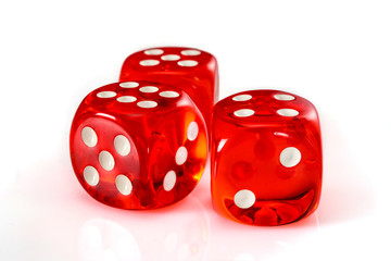 Red acrylic transparent dice for games. Three gambling translucent dices on white background, close-up high resolution.