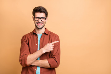 Close-up portrait of his he nice attractive cheerful cheery glad successful content brunet guy pointing forefinger aside advice advert solution isolated over beige color pastel background