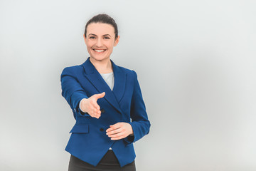 Beautiful teacher standing, extending her hands to the camera, as if wanting to shake it with someone, greeting.