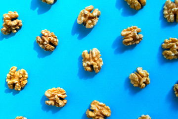 Walnuts pattern on blue background. Walnuts flat lay, top view.
