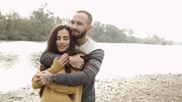 couple hugs in the park with river on the background. Autumn mood