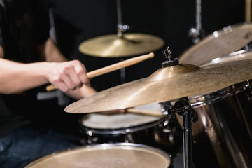 Close up of cymbal and man hand holding drumstick