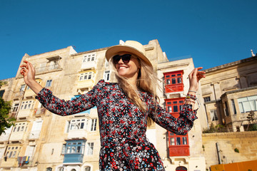 Happy young carefree woman enjoying sightseeing in Valletta - obrazy, fototapety, plakaty