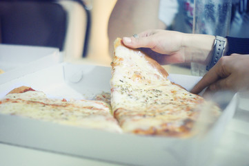 Friends eating mozzarella pizza at home party, closeup