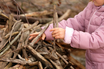 Mid section of a 4 year old child girl in purple warm clothing building something with wooden...