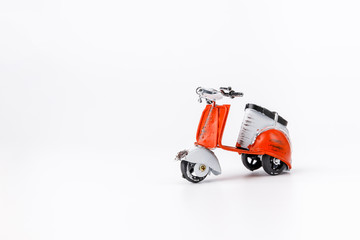 Miniature toy red and white retro scooter  on white background. Metal model.