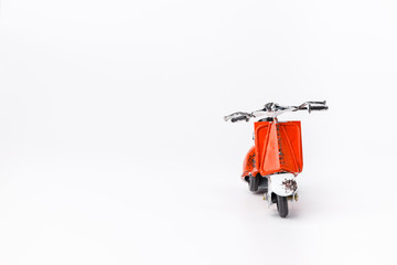 Miniature toy red and white retro scooter  on white background. Metal model.