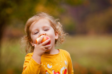 Cute little girls eating red delicious apple