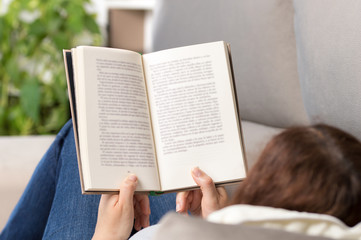 Naklejka premium reading an book sitting on a couch