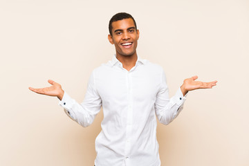 Young handsome brunette man over isolated background with shocked facial expression