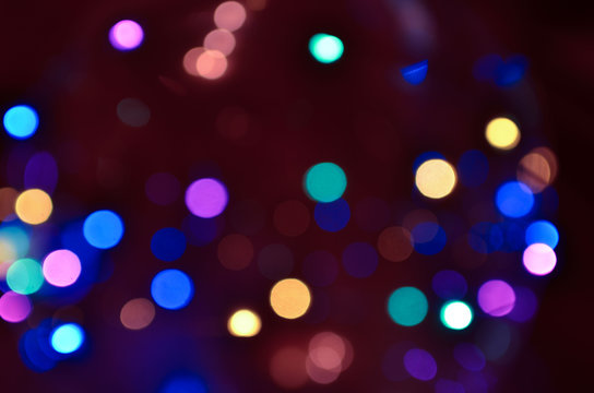 Night city lights on Christmas night. New Year, colored garland in defocus. Multi-colored bokeh on a dark background for photoshop.
