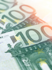 Vertical closeup of a few paper notes in denominations of 100 Euros