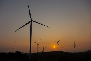 Obraz premium Wind turbines field new technology for clean energy on mountain at sunset.