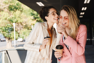 Two beautiful young businesswomen walking outdoors