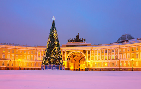 Saint Petersburg in Christmas holidays. Decorated Christmas tree on a snowy Palace Square against the background of General Staff Building. Translation inscription: Merry Christmas and Happy New Year