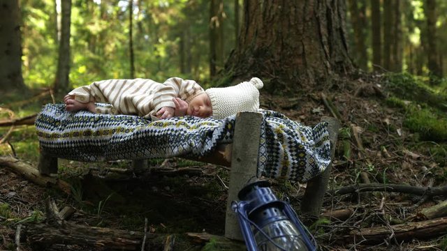 newborn baby sleeps soundly in a crib in the forest