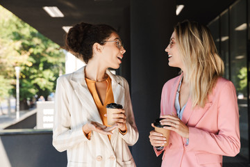 Two beautiful young businesswomen walking outdoors