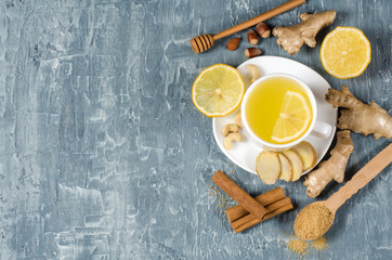 Ginger tea with lemon in a white cup on a gray concrete table