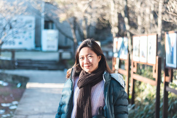 Beautiful young Asian woman in her winter jacket, traveler concept.
