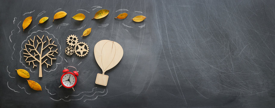 Education concept, banner of vintage air balloon on a chalkboard with fall leaves