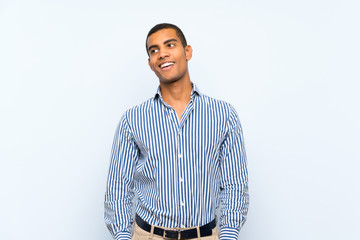 Young handsome brunette man over isolated blue background laughing