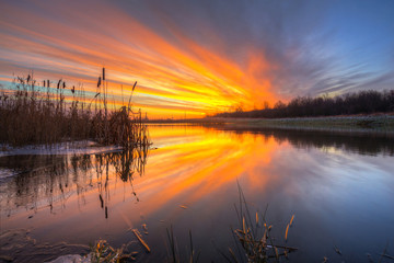 Obraz premium Beautiful sunrise over the pond at winter, Poland