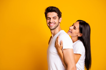 Profile photo of amazing pair in love lady holding piggyback strong back of guy wear casual white t-shirts isolated yellow color background
