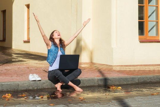 Happy Businesswoman Outdoors With Barefoot In Water Stream After Rain