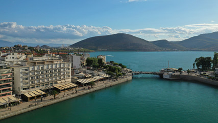 Aerial drone photo of famous seaside town of Halkida or Chalkida with beautiful clouds and deep blue sky featuring old bridge connecting Evia island with mainland Greece