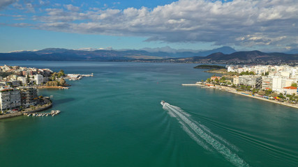 Fototapeta premium Aerial drone photo of famous seaside town of Halkida or Chalkida with beautiful clouds and deep blue sky featuring old bridge connecting Evia island with mainland Greece