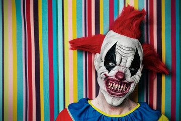 scary evil clown in front of a circus tent
