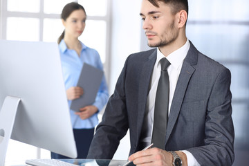 Businessman working with computer in modern office. Headshot of arab male entrepreneur or manager at workplace. Business concept